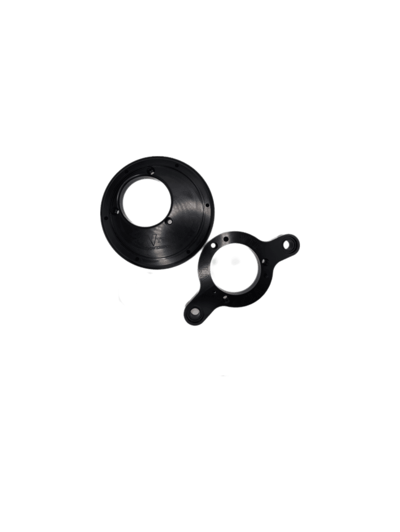 Two black metal mechanical parts: one circular with multiple holes, the other irregularly shaped with three holes, identified as the M8 Trask Turbo Plenum Backing Plate for 70mm On Center.